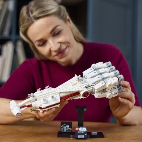 Adult placing Lego Star Wars Tantive IV on display stand