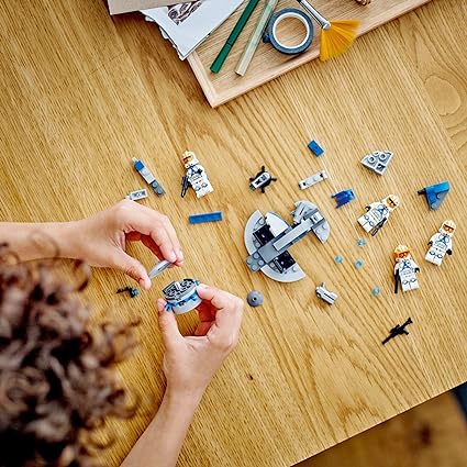 Overhead view of child building Lego Star Wars 332nd Ahsoka's Battle Pack.